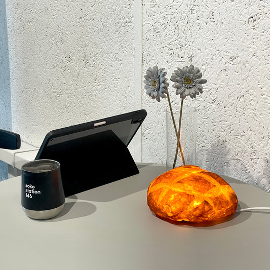 PAMPSHADEのブール(コンセントタイプ)インテリアランプはパン屋さんからロスパン(廃棄パン)を回収して作られた間接照明。パンから滲む温かい光がお部屋を照らします